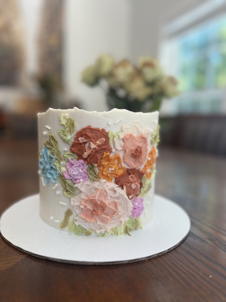 Ivory cake with multicolor palette-knife flowers in cocoa, blush, marigold, and sage