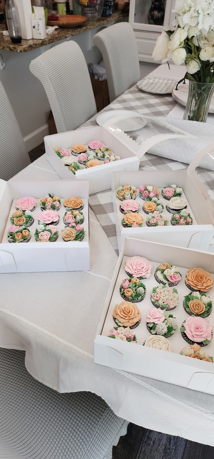 Multiple boxes of flower cupcakes arranged on a table