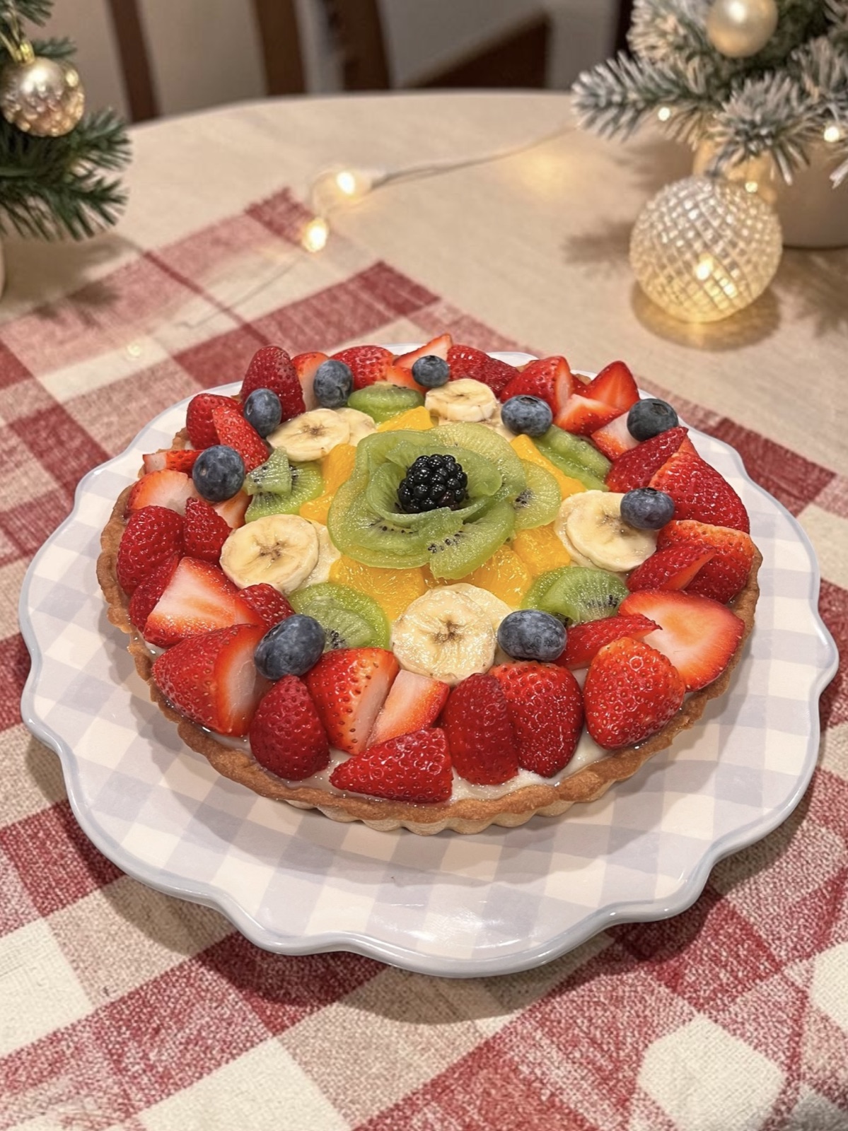 Round fruit tart with strawberries, blueberries, kiwi, banana, and a blackberry center