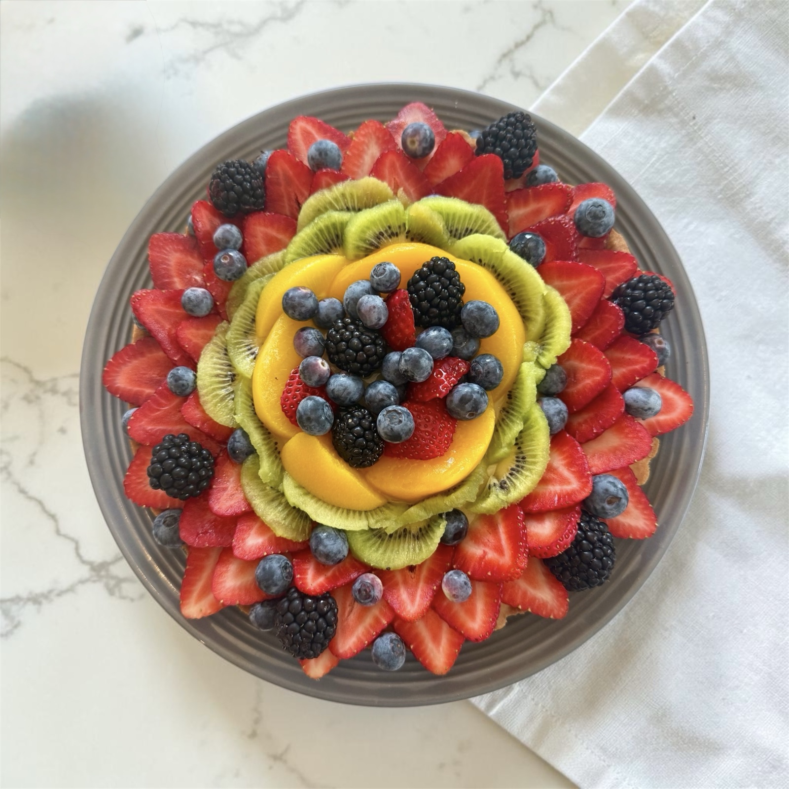 Top-down view of the sunset fruit tart on a gray plate