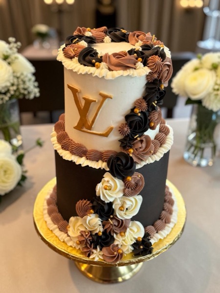 Two-tier cream and espresso cake with gold monogram and chocolate rosette cascade