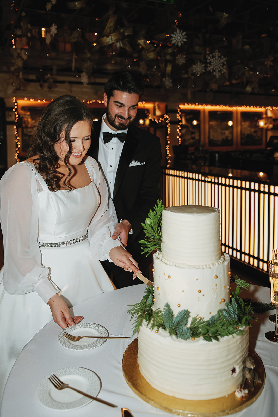 Bride and groom cutting the winter wedding cake at reception